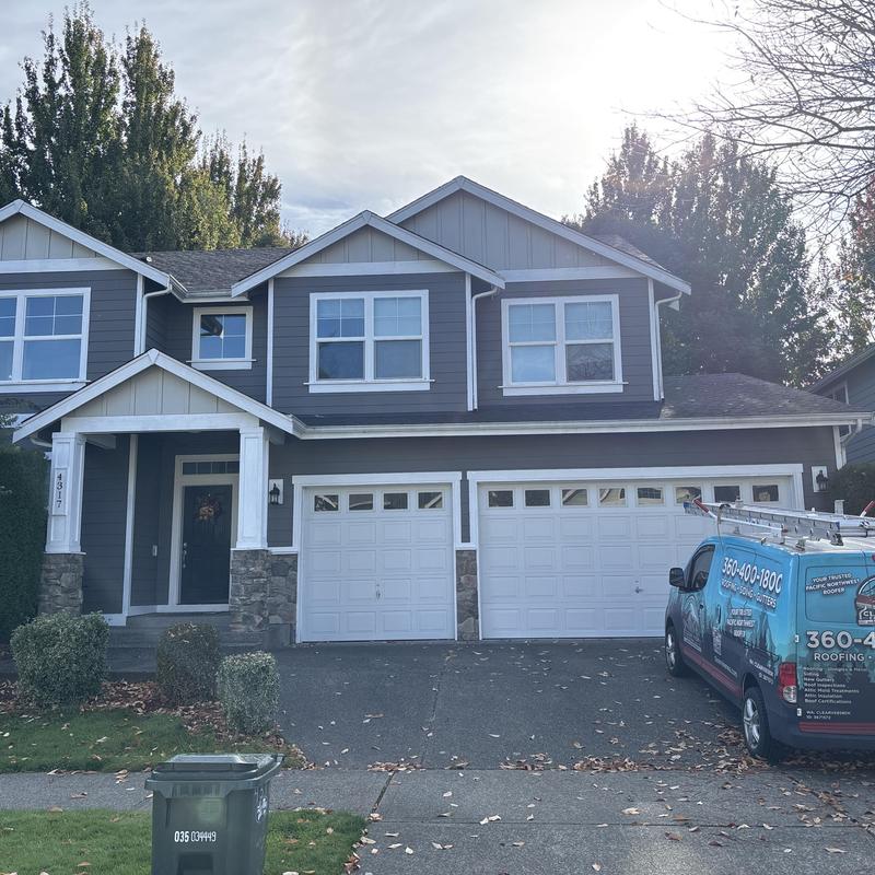 Asphalt shingle roof on two-story house with service van