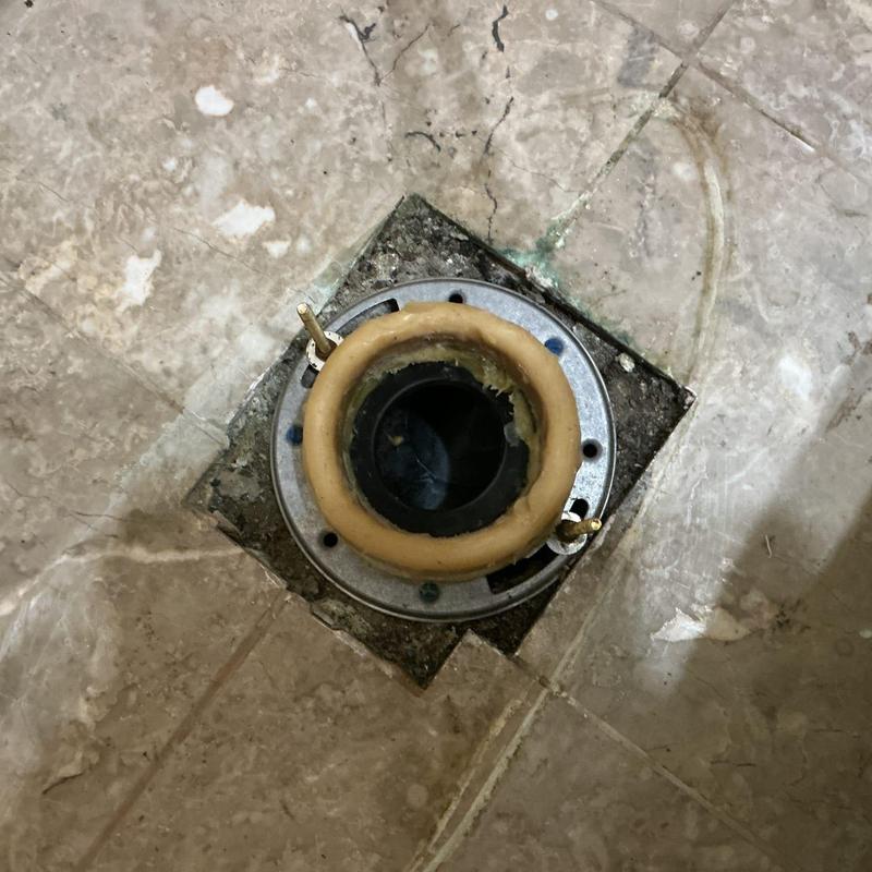 Toilet flange installation on tiled floor in bathroom