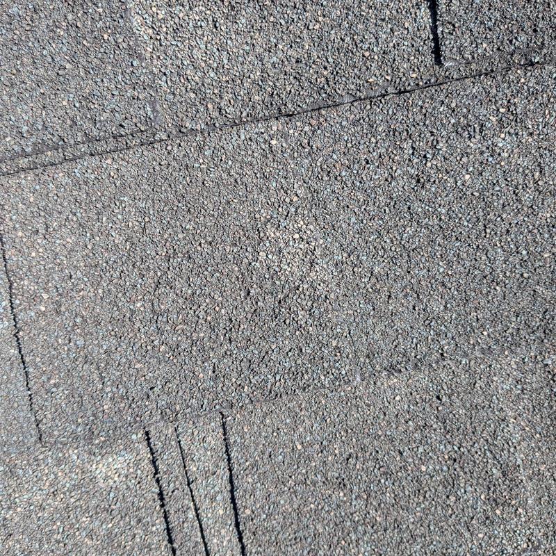 Roof shingles with visible hail damage granules