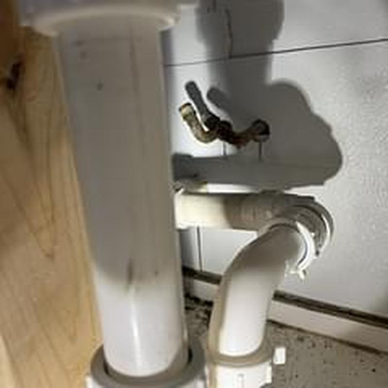 Sink drain pipe and water lines adjusted under cabinet