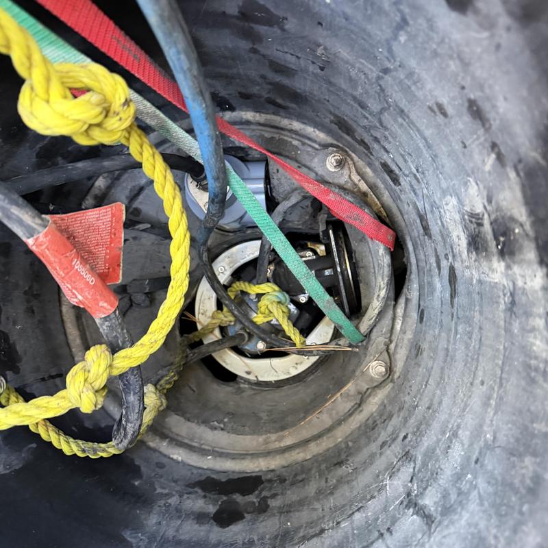 Grinder pump basin with electrical cables and straps Grinder pump basin with electrical cables and straps