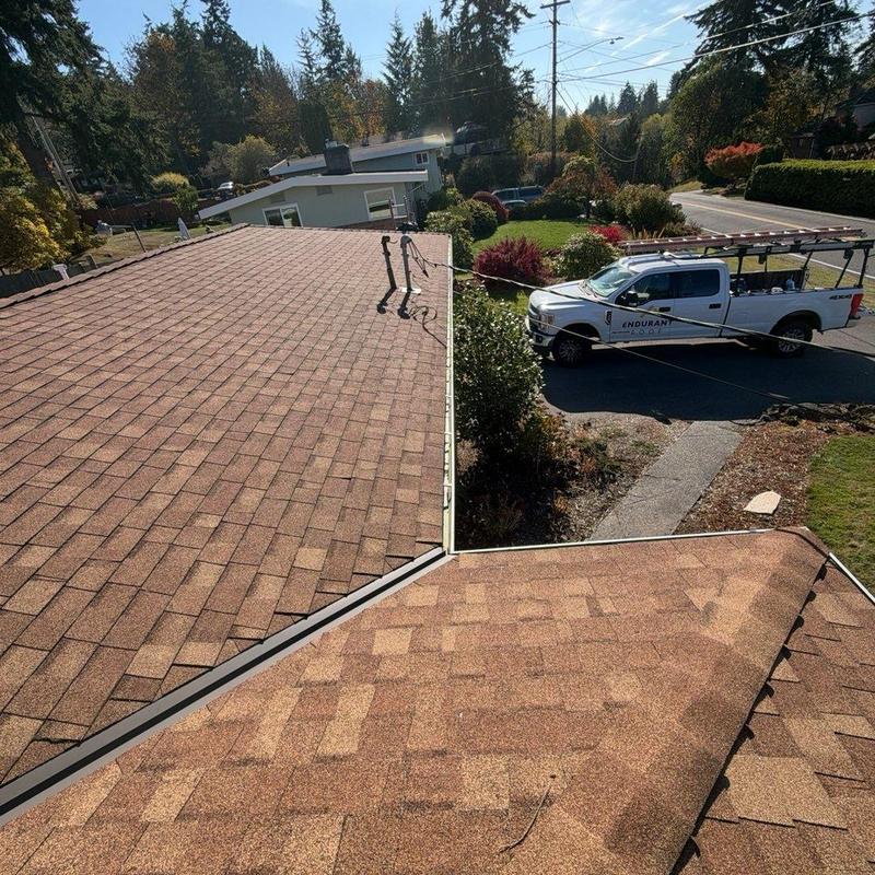 Roof shingles and gutters with maintenance truck nearby