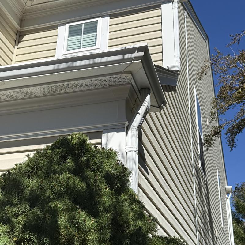 Gutter and downspout system on beige siding house Gutter and downspout system on beige siding house