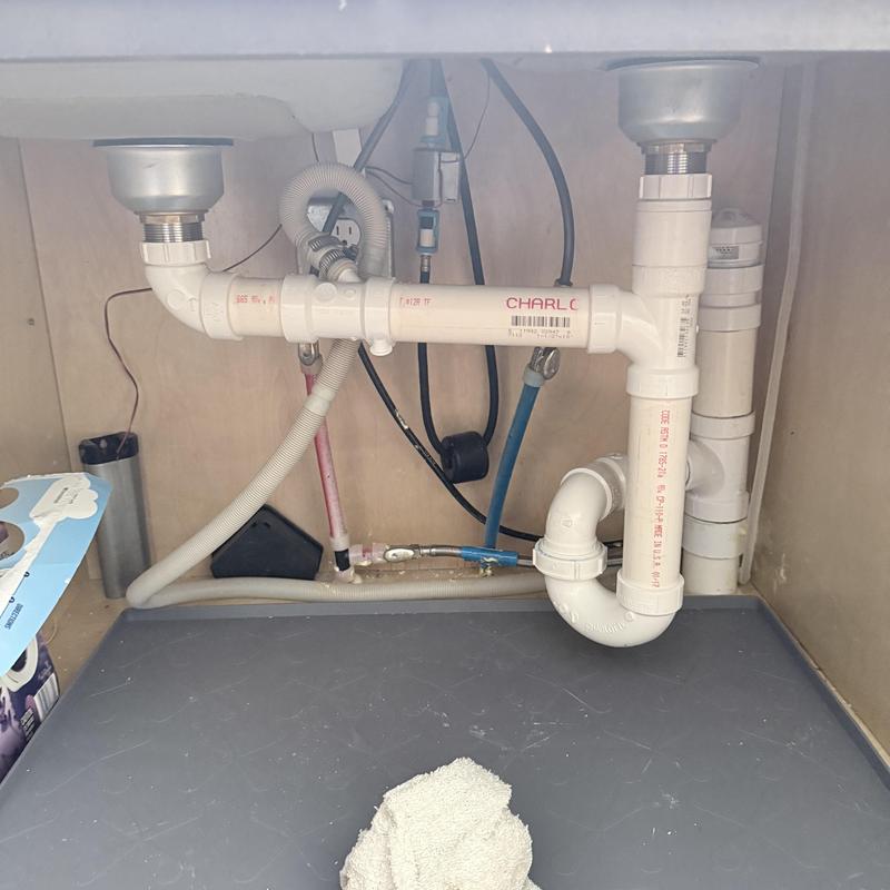 PVC kitchen sink drain pipes and connections under cabinet
