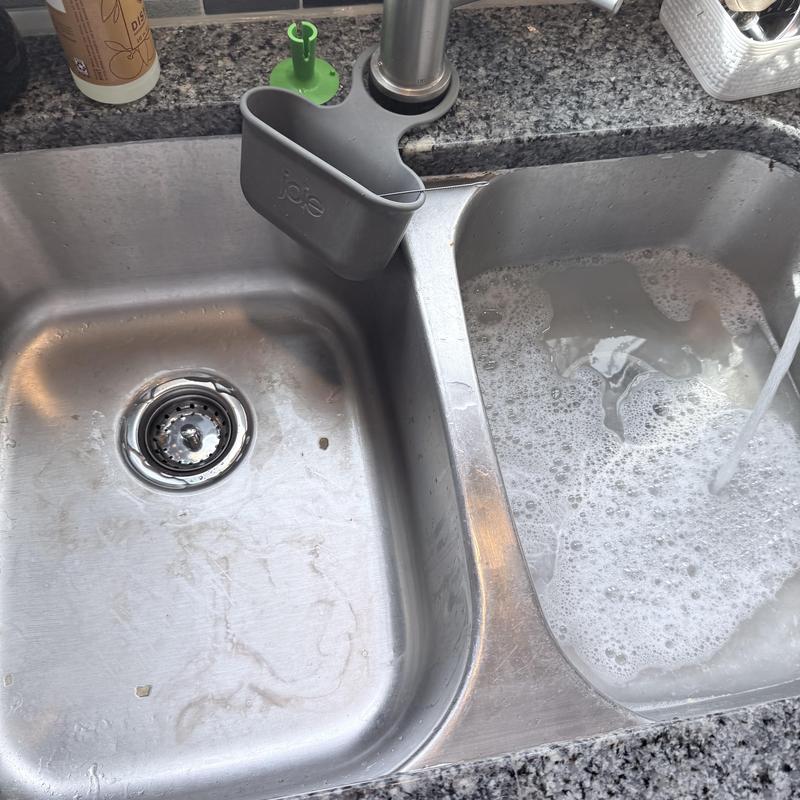 Kitchen sink drains with running water and soap suds