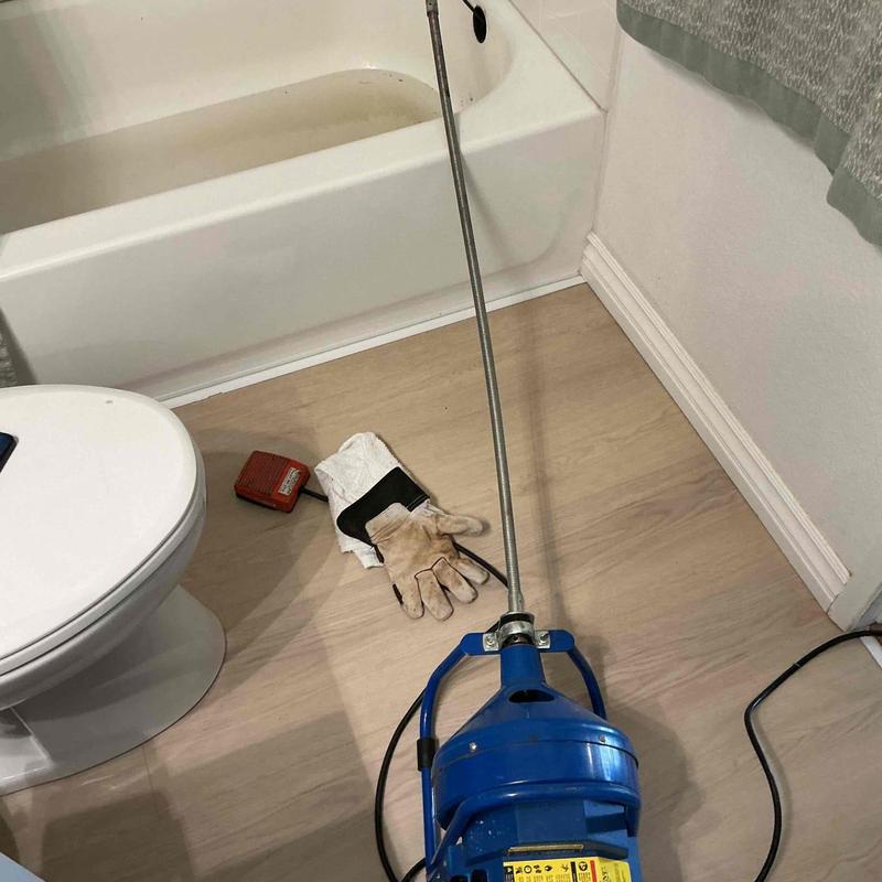 Bathtub drain cabling tool with gloves on floor