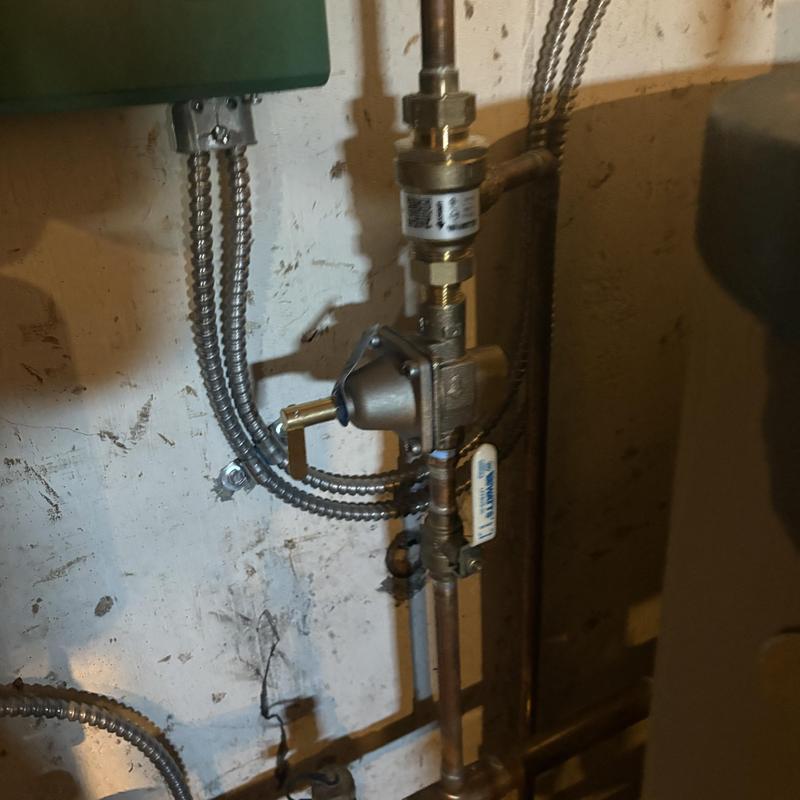 Pressure regulator backflow assembly with piping in basement