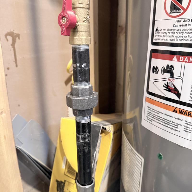 Gas line piping near water heater with shutoff valve