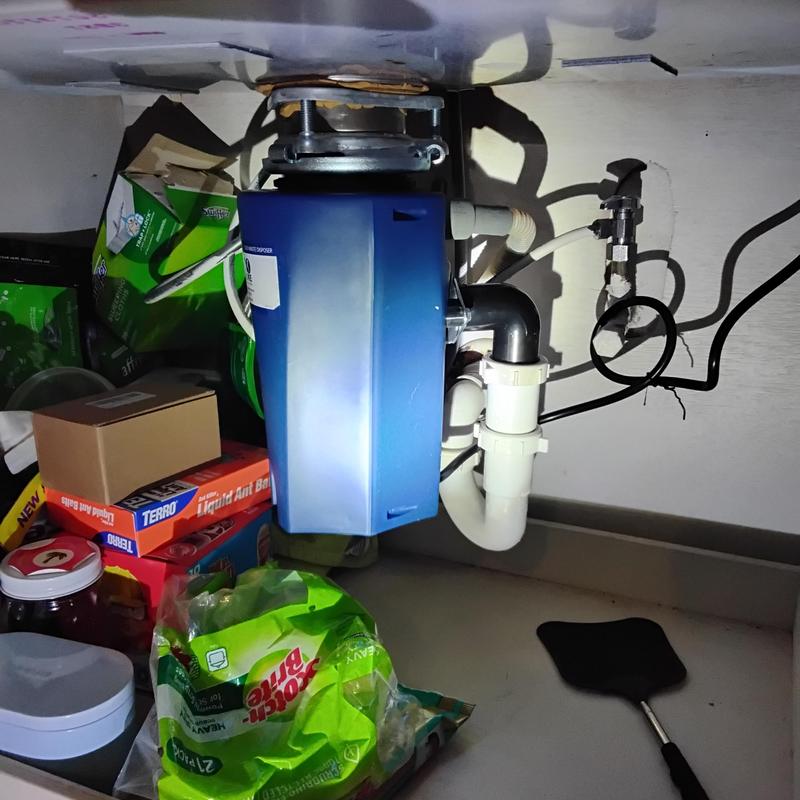 Garbage disposal unit with plumbing connections under sink