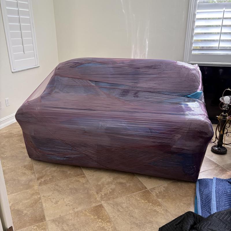 Wrapped sofa secured for moving in living room