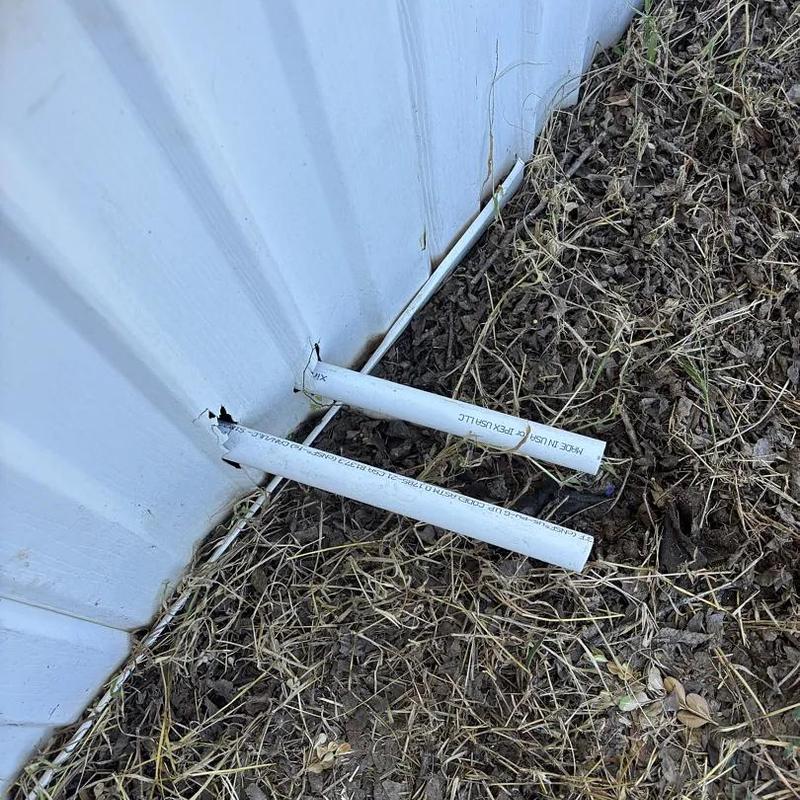 Broken PVC drain pipes outside metal building wall Broken PVC drain pipes outside metal building wall