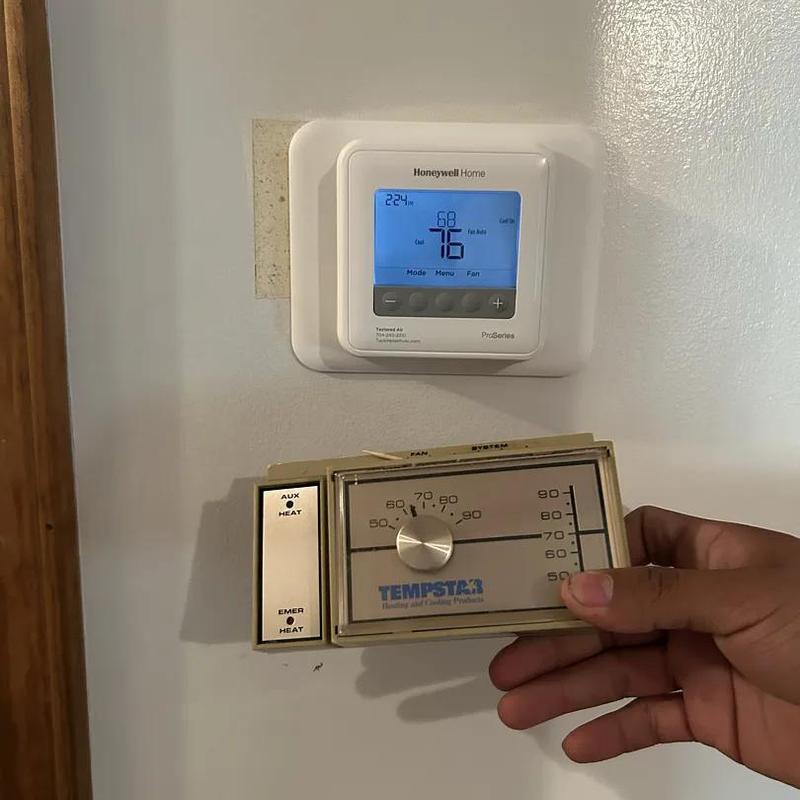 Thermostat replacement showing old and new units on wall Thermostat replacement showing old and new units on wall