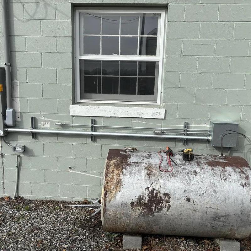 Oil burner fuel tank with electrical conduit on wall Oil burner fuel tank with electrical conduit on wall