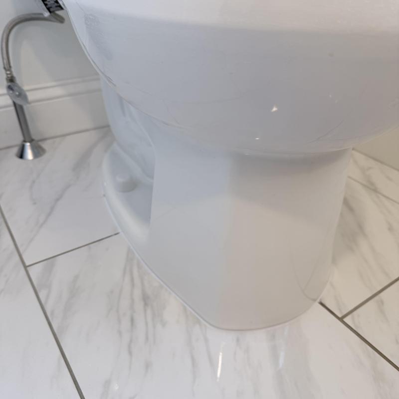 Toilet base and flange on marble tile floor