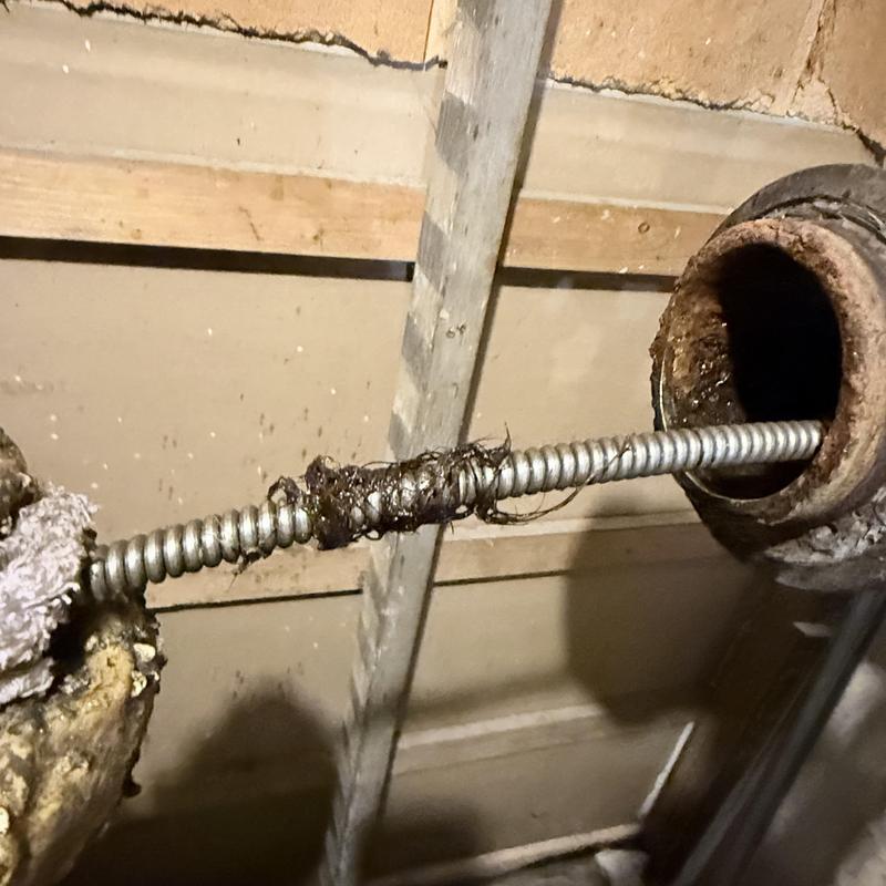 Main drain pipe with roots cleared using auger tool