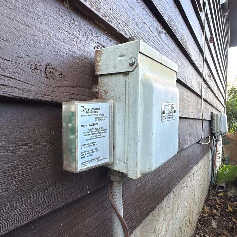 Surge protective device on electrical panel exterior wall Surge protective device on electrical panel exterior wall