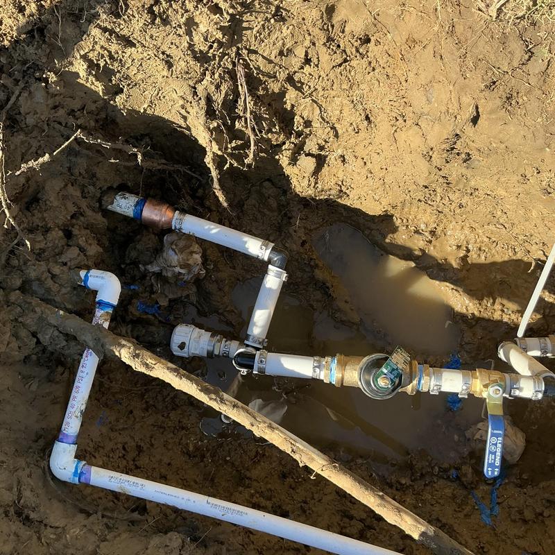 Main water line with ball valve and pressure reducer in soil