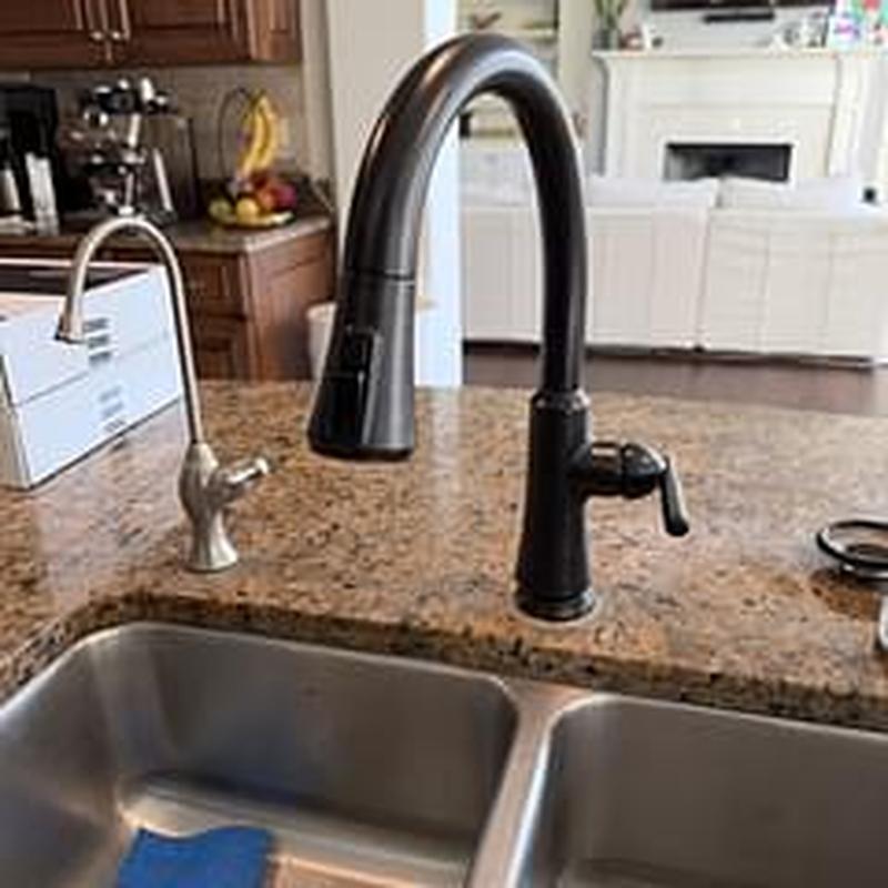 Black kitchen faucet installed on granite counter