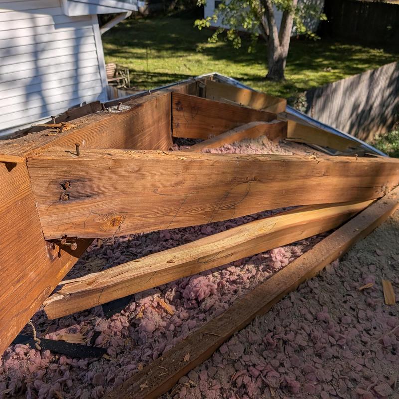 Roof framing wood removed with insulation exposed
