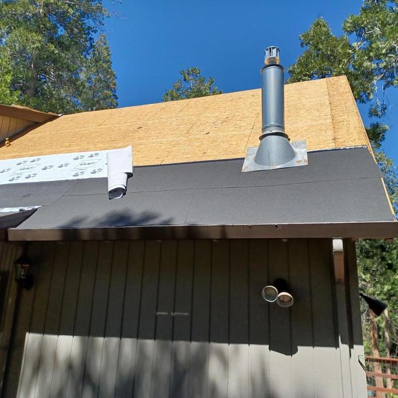 Asphalt roof underlayment installation on cabin roof