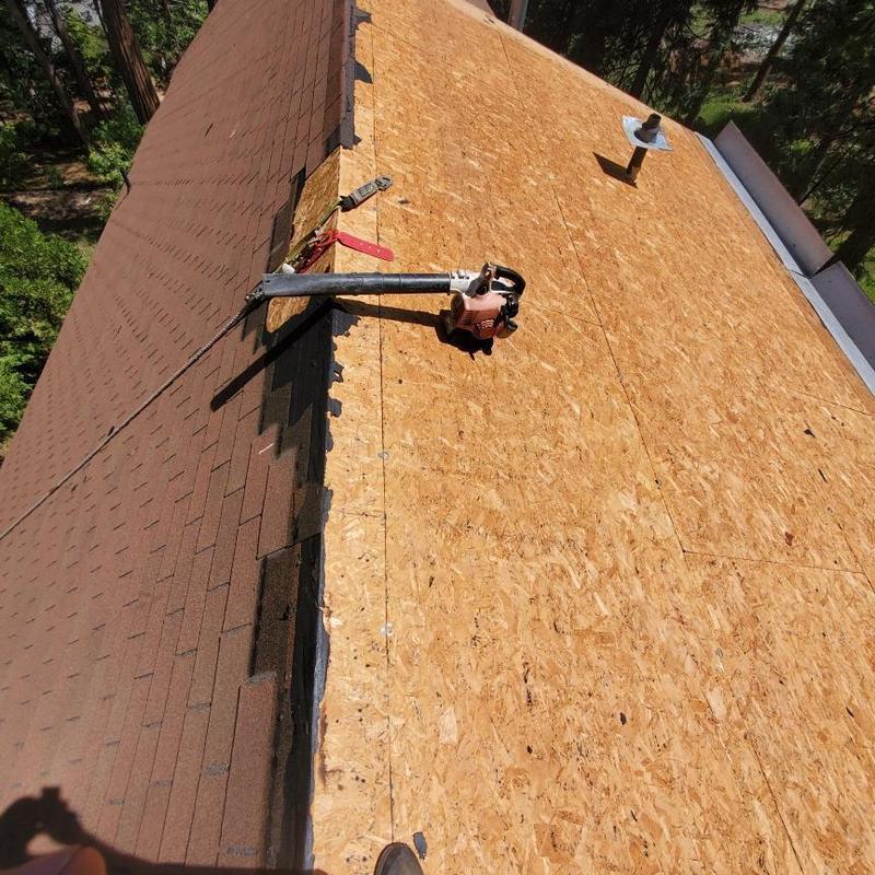 Asphalt roof sheathing replacement with tools on roof