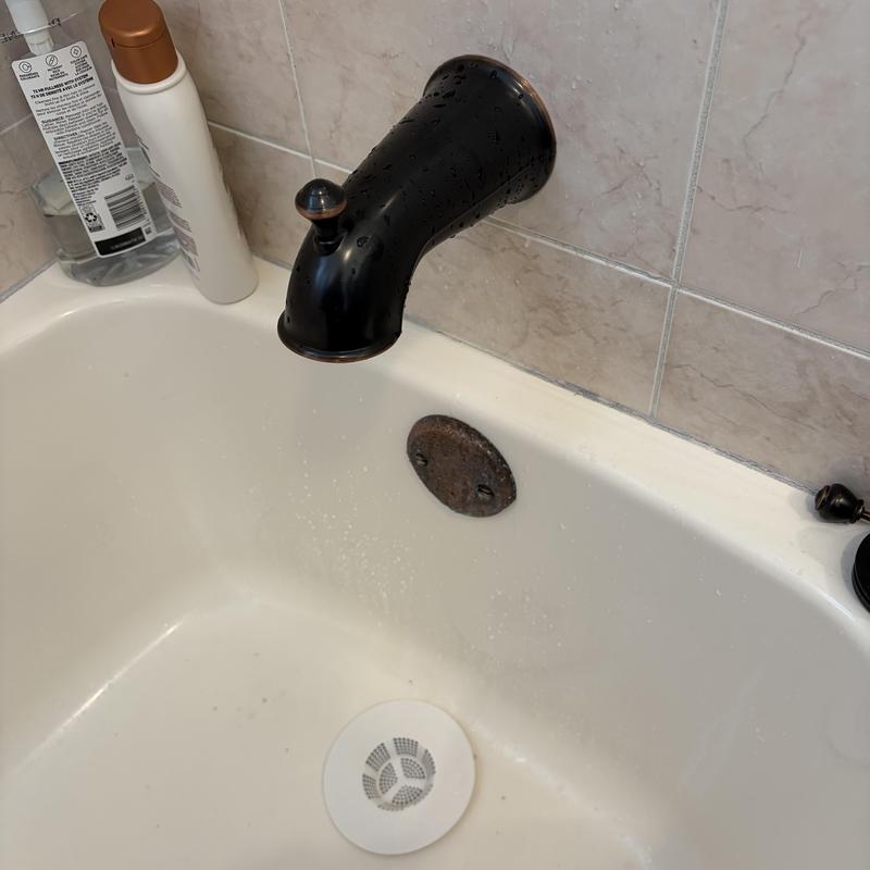 Tub spout with diverter installed over bathtub drain