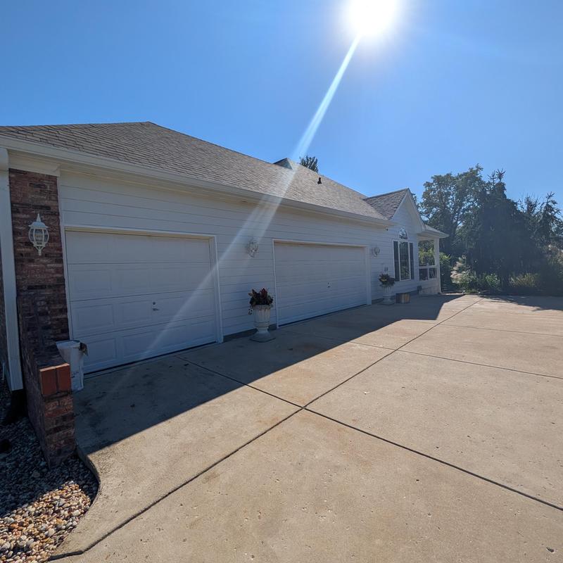 Garage doors and driveway exterior with sun glare