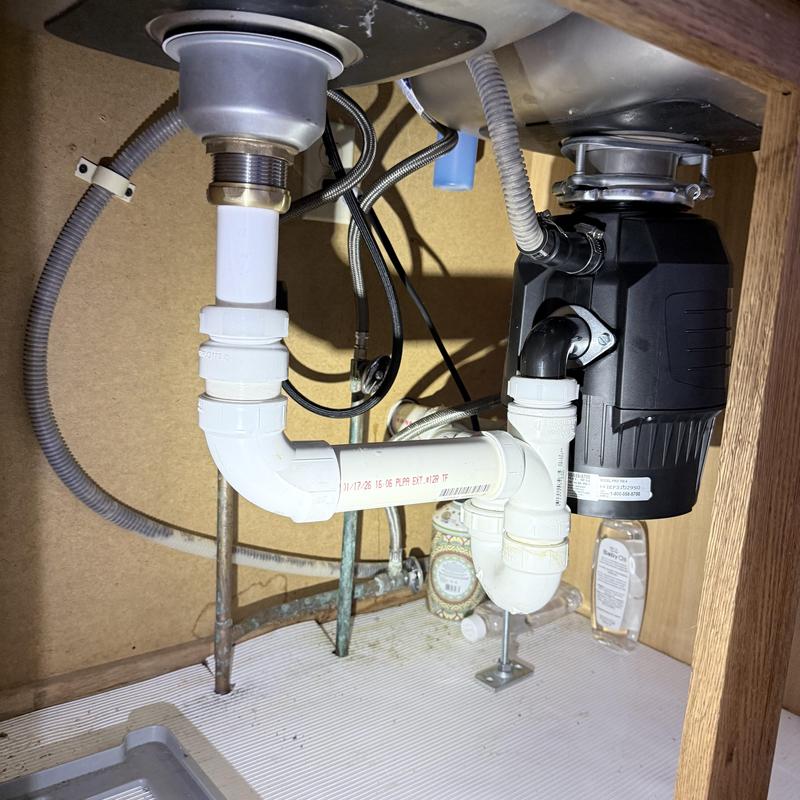 Garbage disposal and sink drain plumbing installation under cabinet