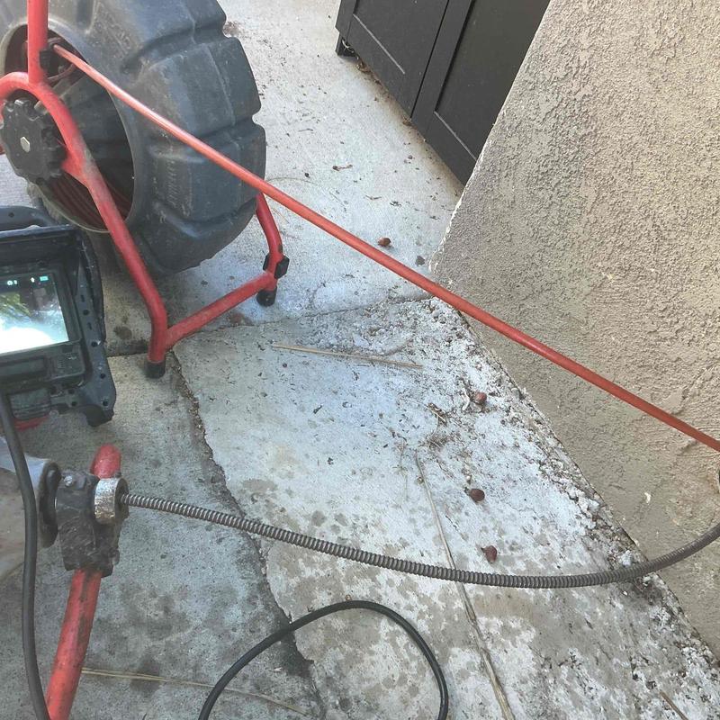 Kitchen drain cleanout cable snake on concrete floor