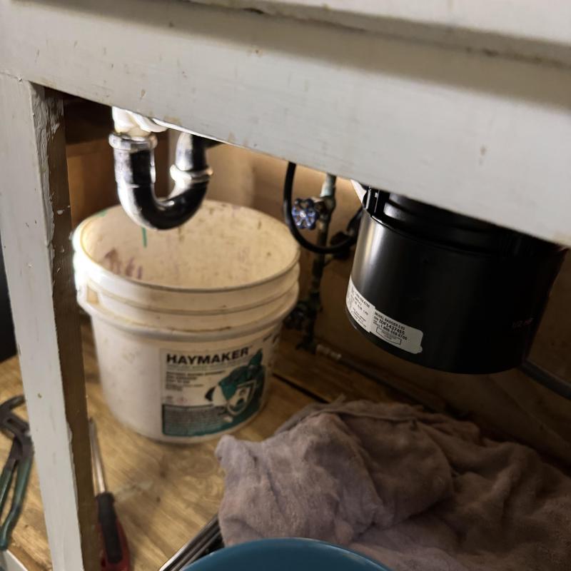 Garbage disposal and kitchen sink under cabinet with tools