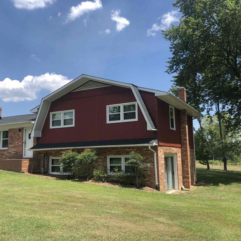 Roofing system on farmhouse in Roxboro under clear sky