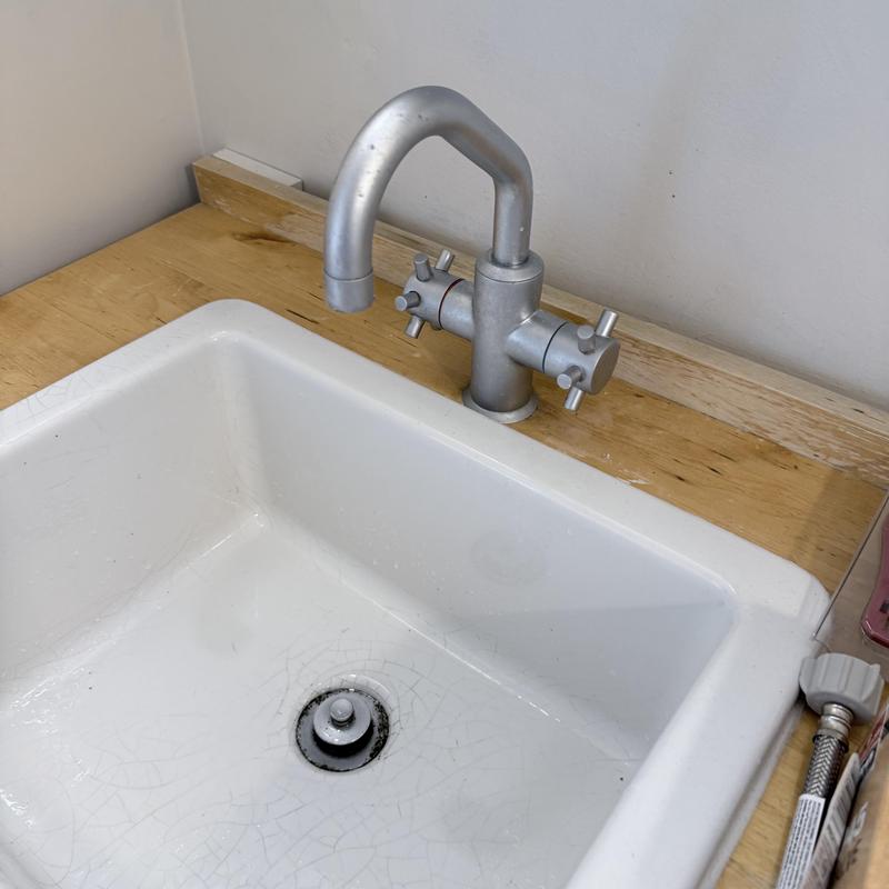 Kitchen faucet with metal handles on wood countertop